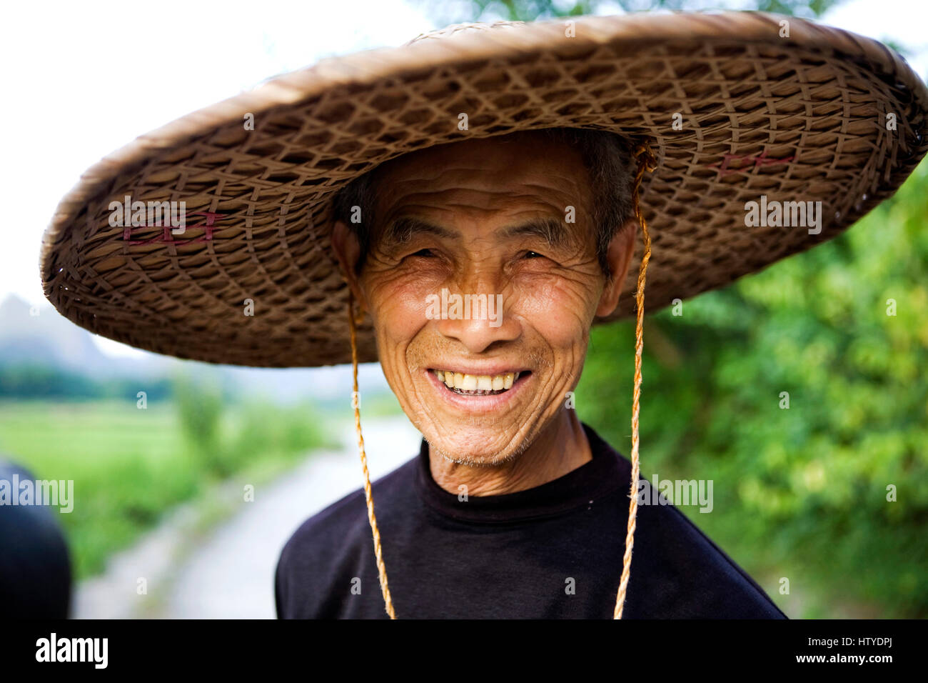 Un fermier chinois porte un chapeau conique traditionnel et sourit au  photographe Photo Stock - Alamy