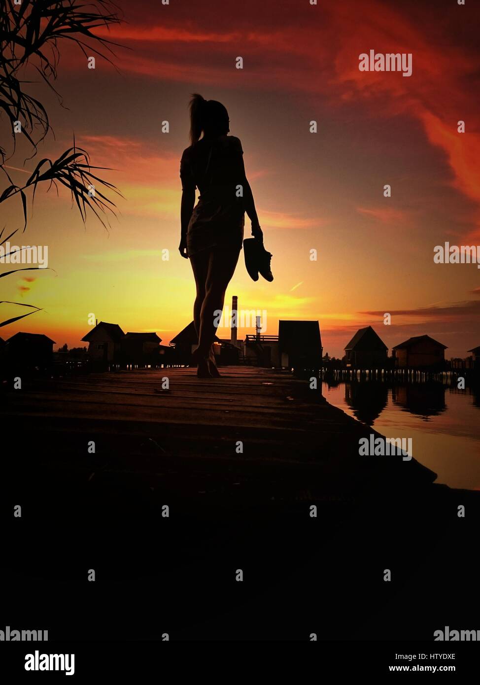 Silhouette d'une femme sur la jetée au coucher du soleil, Bokod, Hongrie Banque D'Images