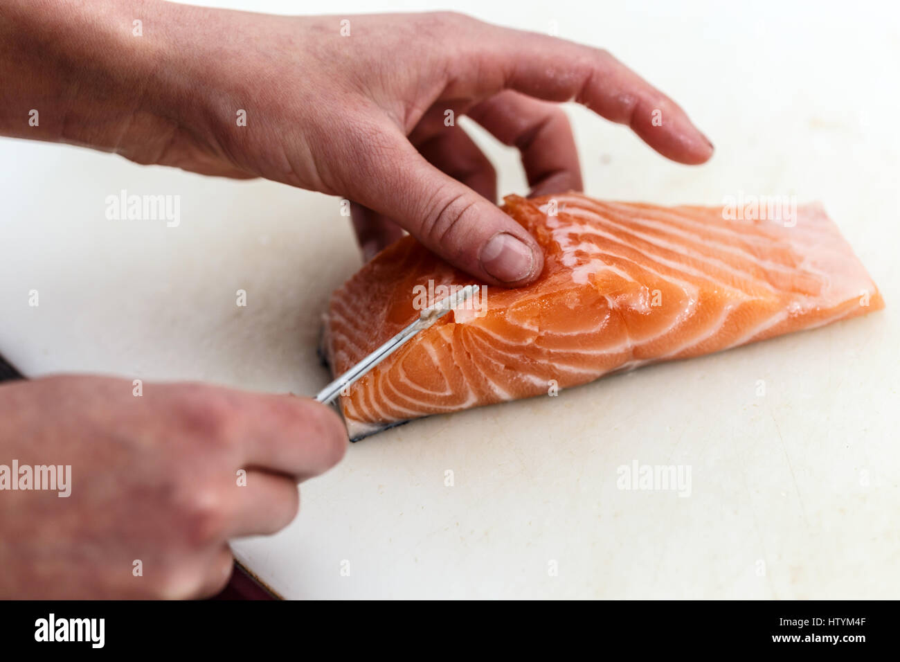 Close up of chef est d'os de poissons saumon de retrait Banque D'Images