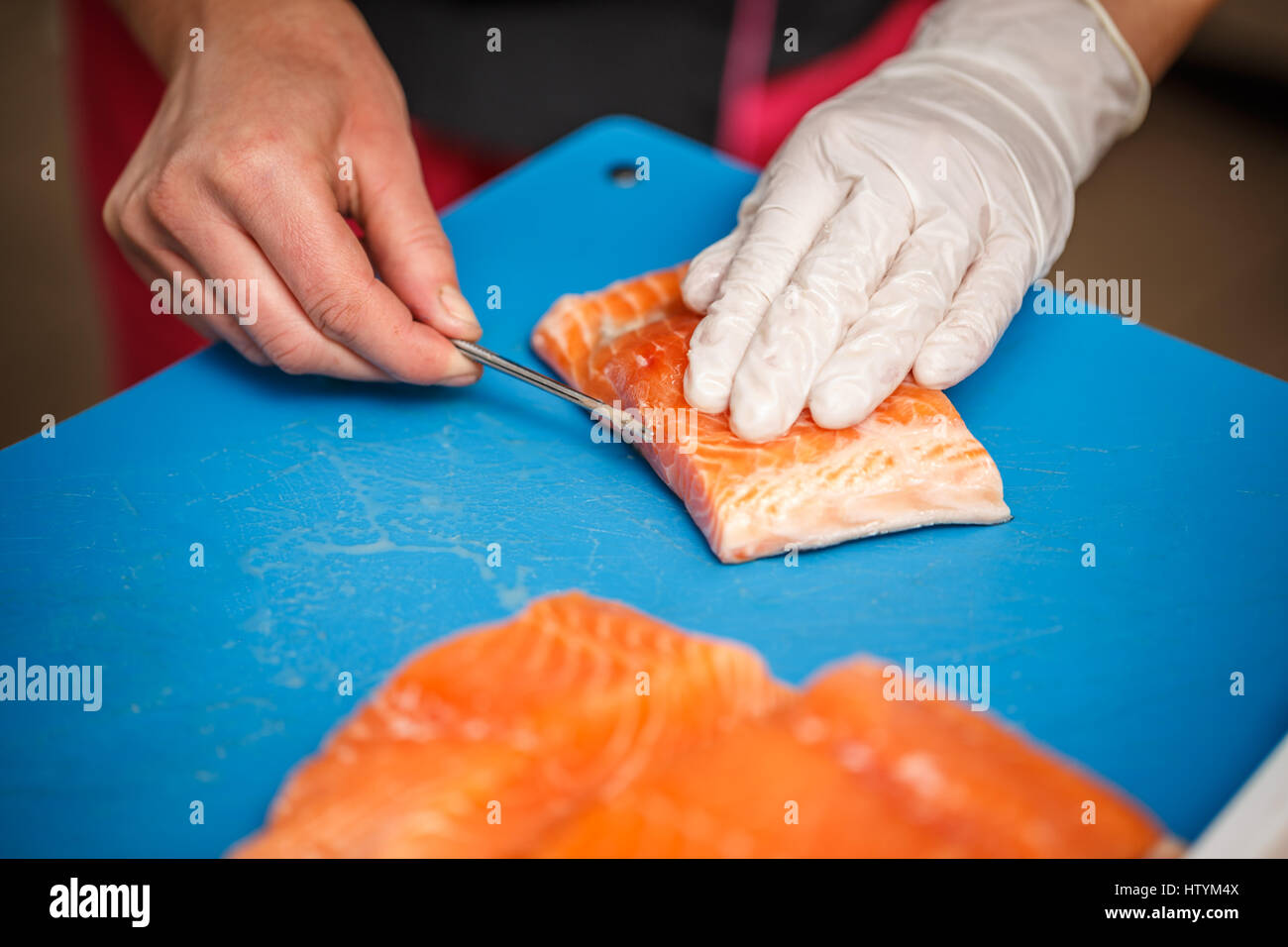 Chef, c'est la dépose de l'os de poissons saumon. Banque D'Images
