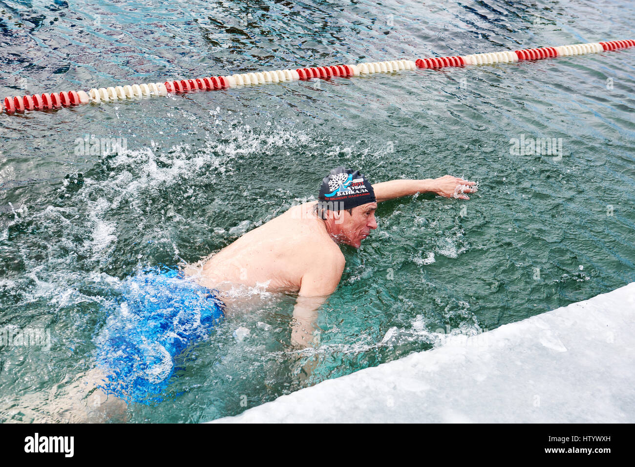 SAHYURTA, région d'Irkoutsk, RUSSIE - Mars 11,2017 : Tasse de Baikal. Les compétitions de natation d'hiver. Un homme nage avec un libre dans l'eau très froide Banque D'Images