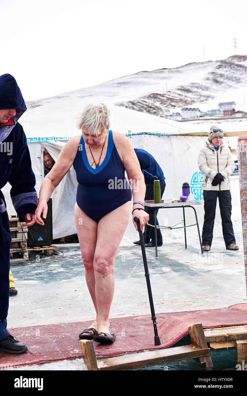 SAHYURTA, région d'Irkoutsk, RUSSIE - Mars 11,2017 : Tasse de Baikal. Les compétitions de natation d'hiver. Une femme âgée est à l'investiture dans l'eau froide Banque D'Images