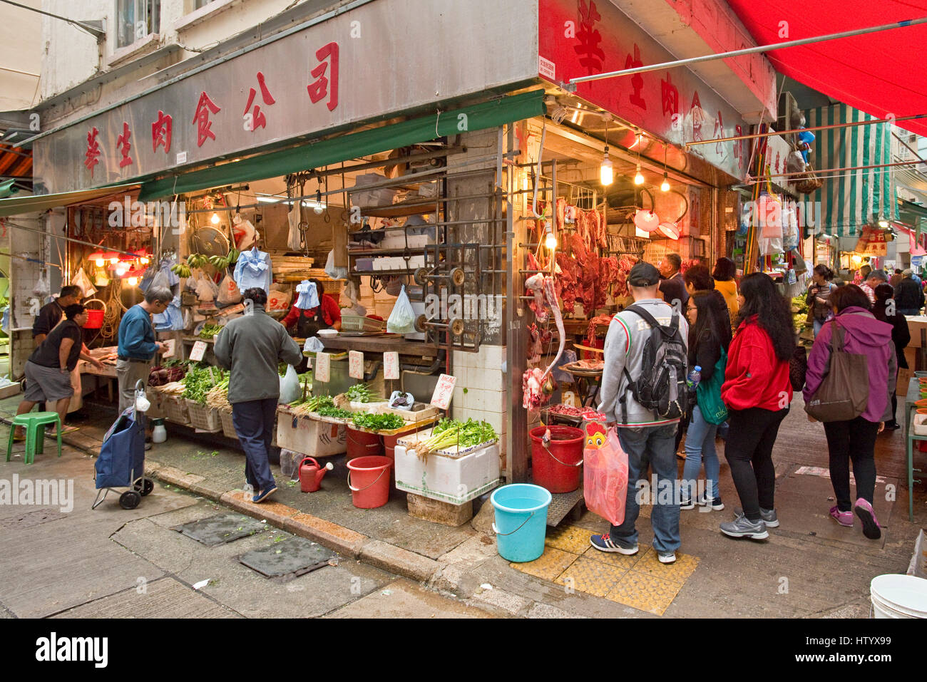 Les gens d'acheter des fruits, légumes, poissons et viandes d'une des boutiques du marché humide de Wan Chai, Hong Kong. Banque D'Images