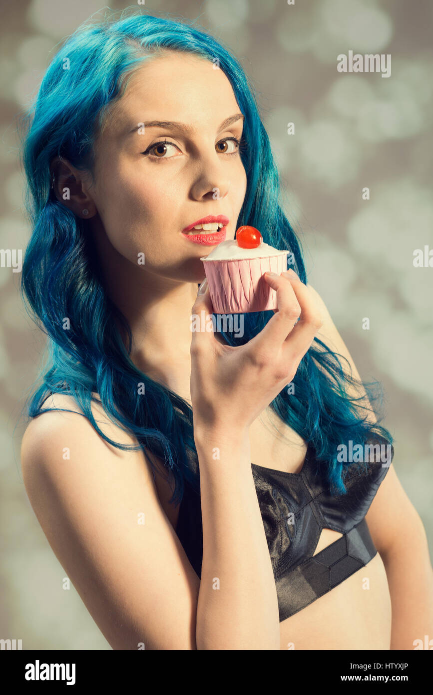 Close up image of style pin up girl holding a cupcake avec cerise sur le haut Banque D'Images