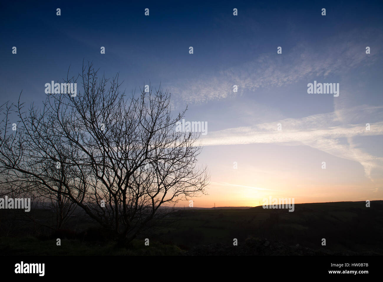 Halifax, Royaume-Uni. Mar 15, 2017. Météo britannique. Le soleil se couche à la fin d'une belle journée de printemps sur les collines des Pennines entourant la ville, Halifax West Yorkshire, Calderdale. Halifax est une ville de la cathédrale dans la région métropolitaine de Calderdale dans West Yorkshire, Angleterre. La ville a été un centre de fabrication de laine du 15ème siècle, à l'origine traiter par la Pièce Hall. Halifax est connu pour guide du chocolat et le caramel produits, y compris la qualité de l'Arlo et rue. La Halifax Building Society a également été fondée à Halifax. Credit : Moulin Images/Alamy Live News Banque D'Images