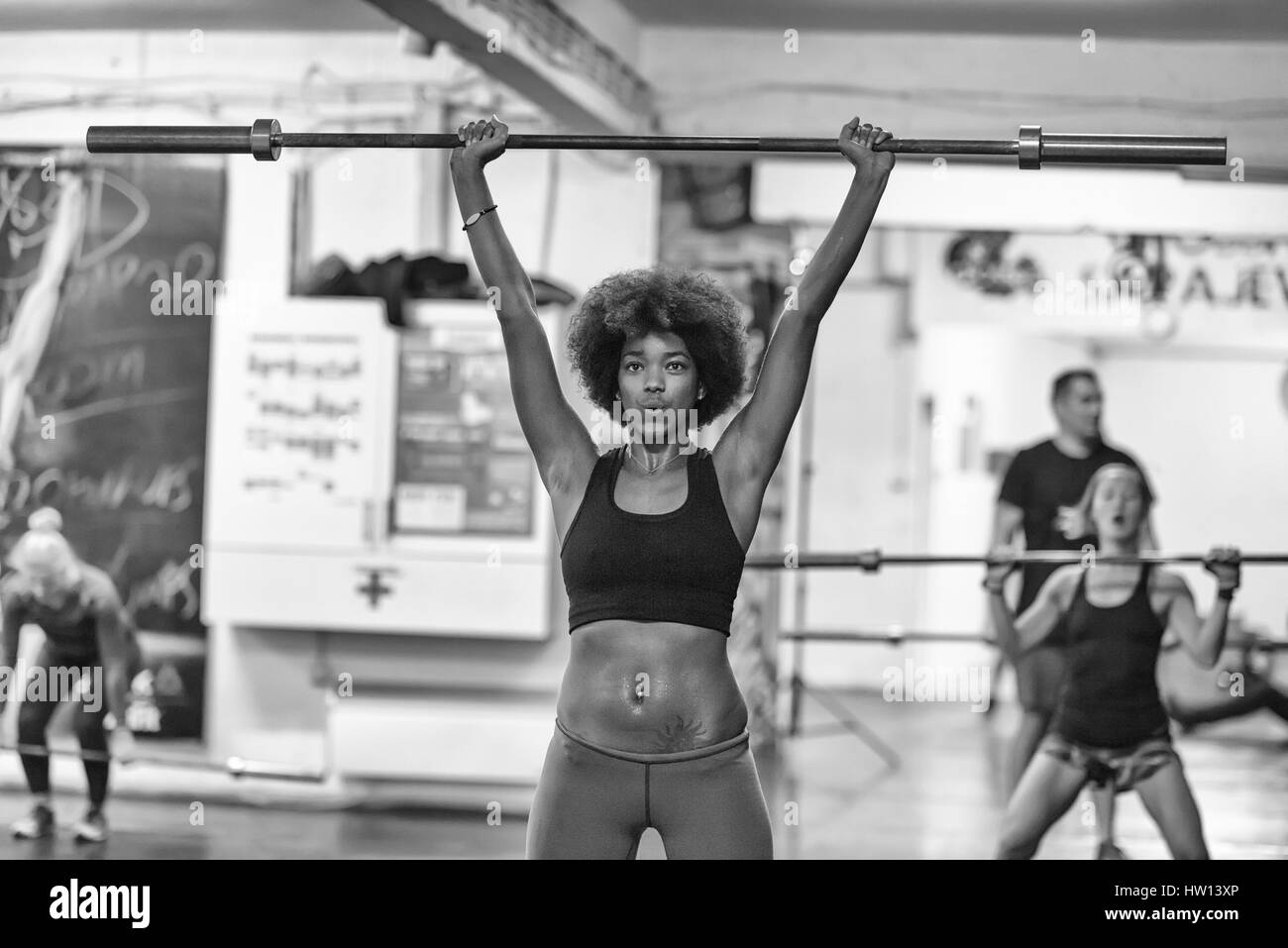 Beaux jeunes african american woman in sport fitness bar vide de levage Banque D'Images