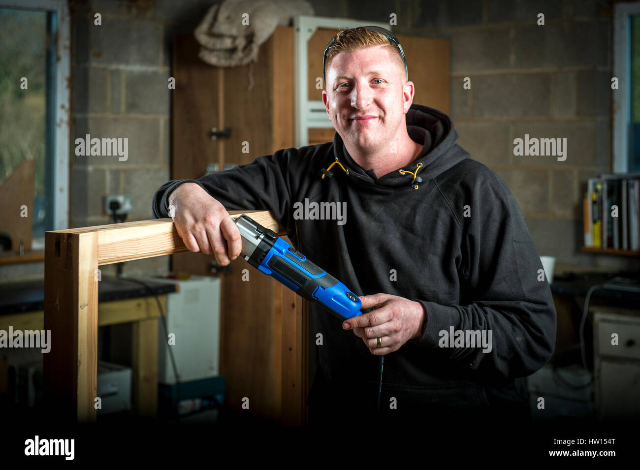 Carpenter en tenant un atelier Multitool Banque D'Images