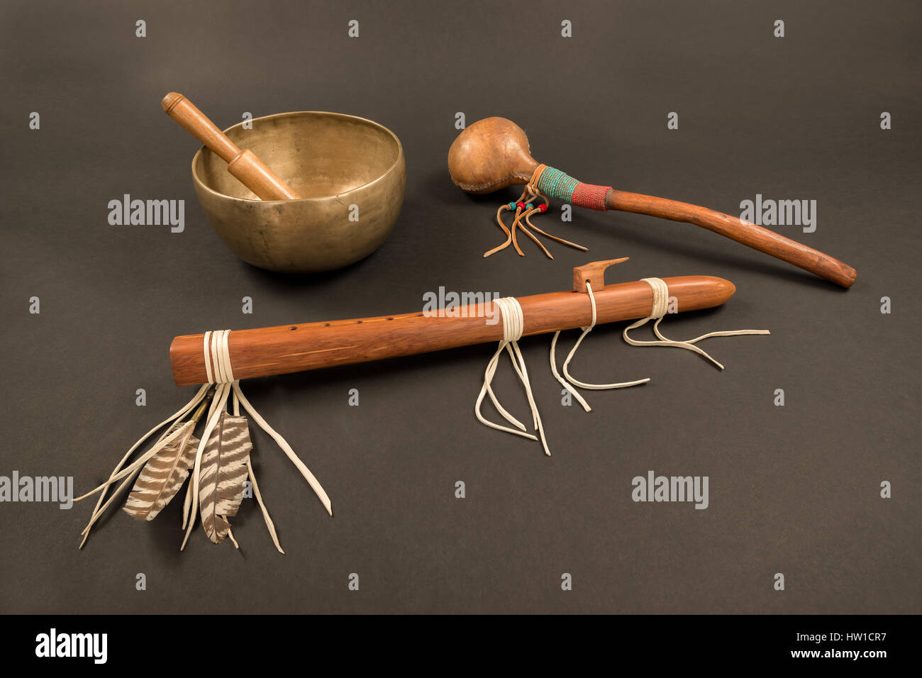 Flûte autochtone avec des plumes et g shaker avec chant tibétain bol et de sonnerie stick. Banque D'Images