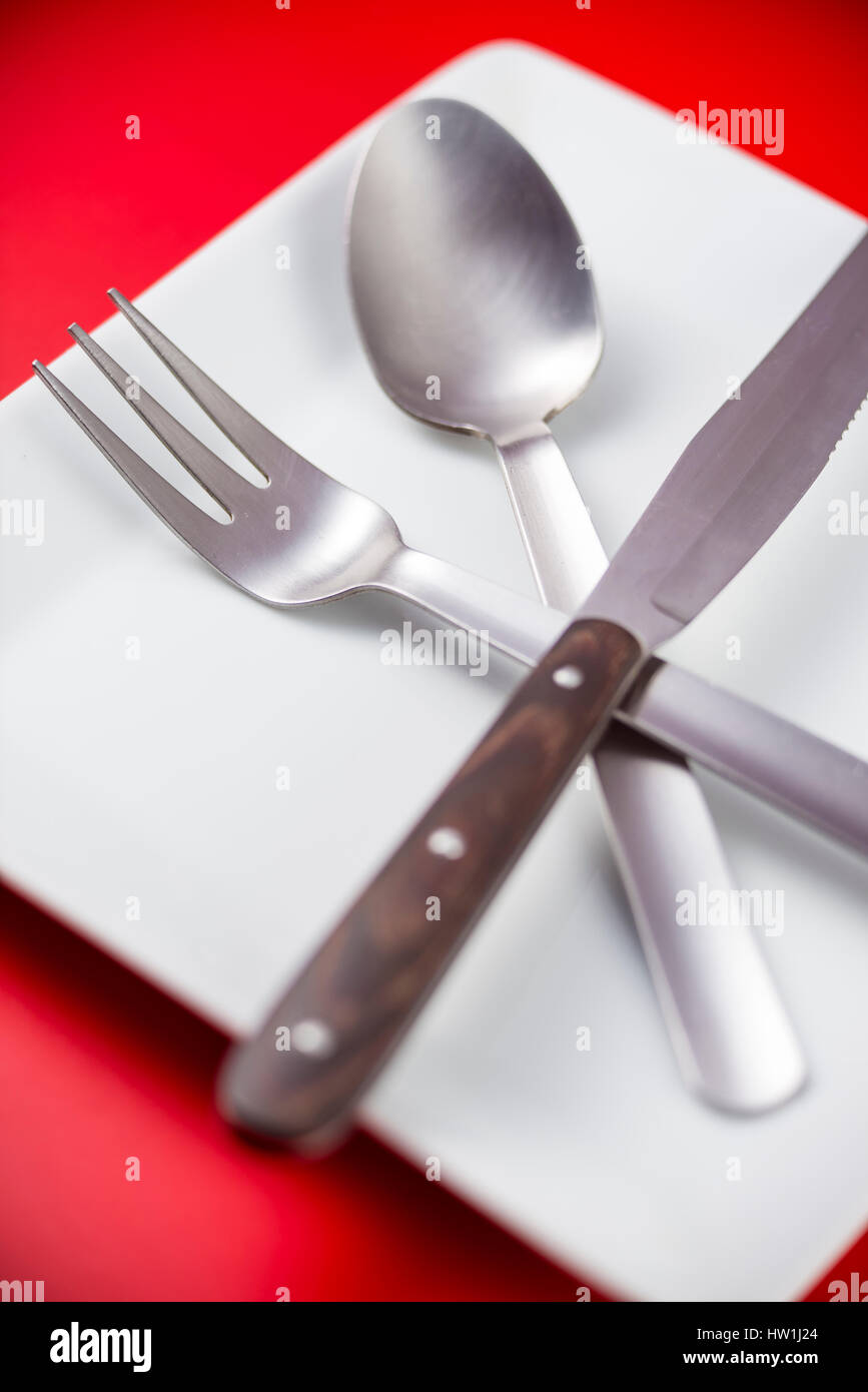 Des couverts et de la plaque avec un fond rouge Banque D'Images