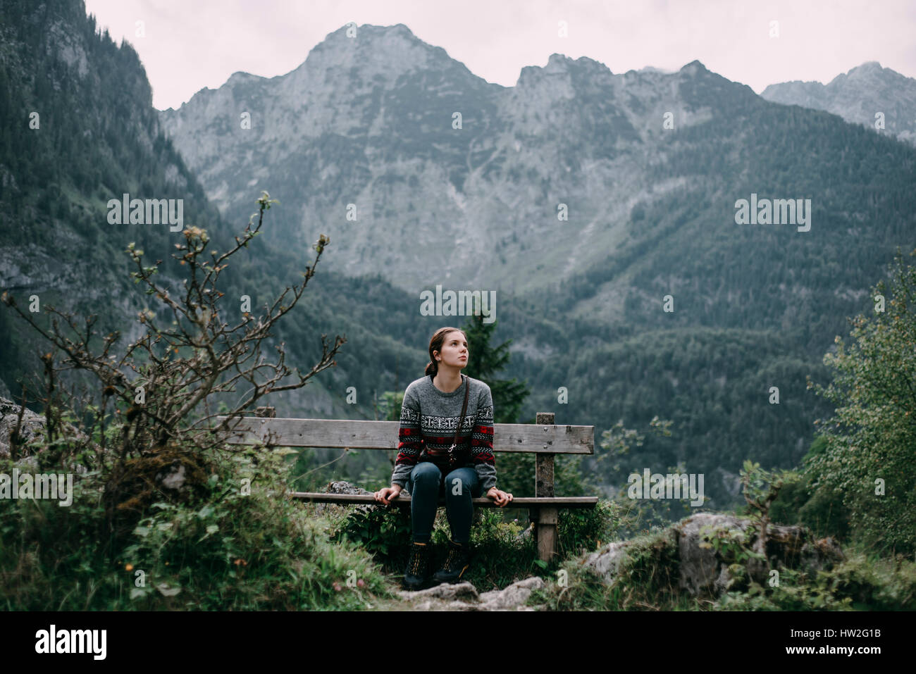 Caucasian woman sitting on bench in mountains Banque D'Images