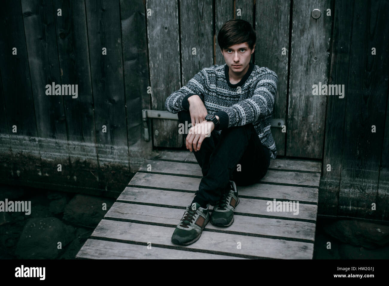 Caucasian man sitting on wooden dock Banque D'Images