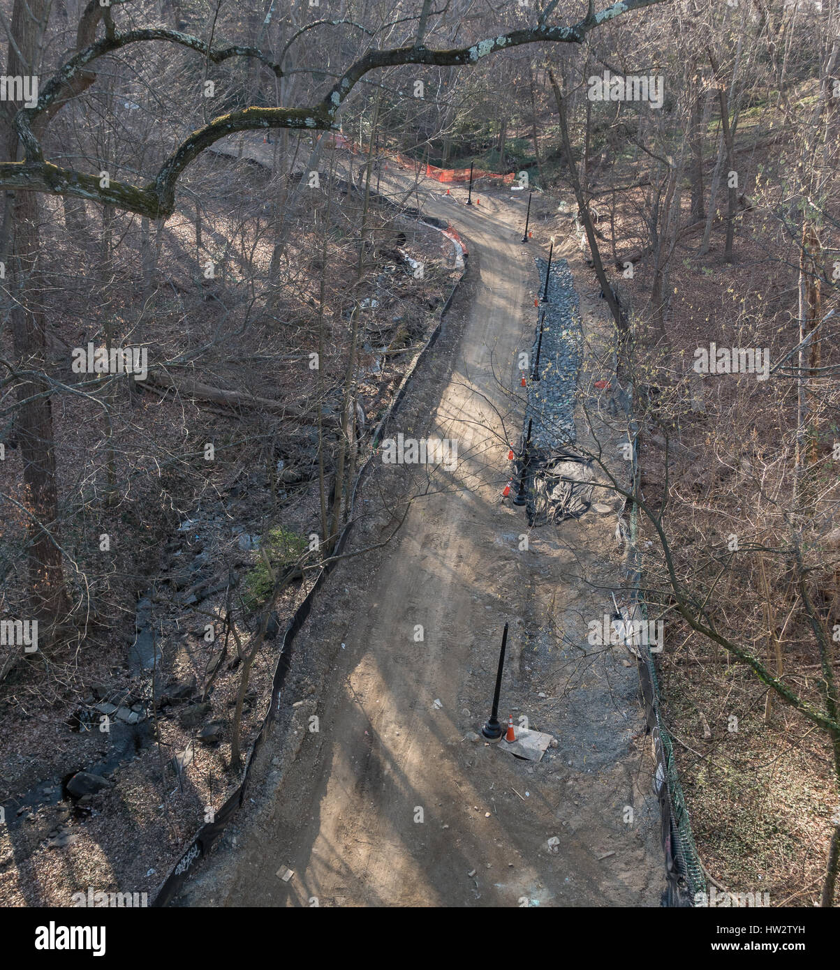 Route en construction, des lampadaires en place pour l'avenir ; des rues et des trottoirs de la route précédente s'est désintégré de l'érosion de l'eau du ruisseau de congélation Banque D'Images