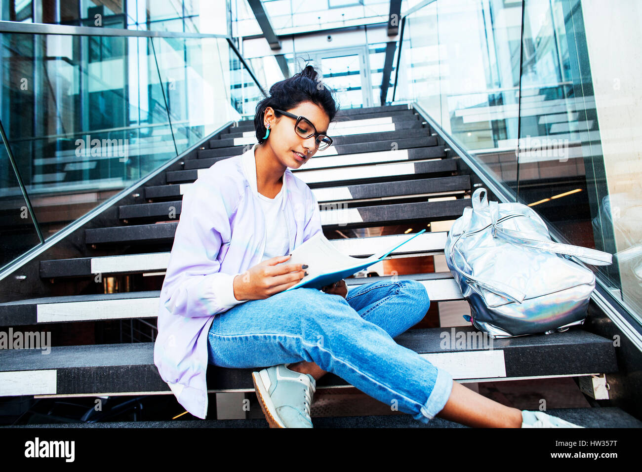 Jeune fille indienne à l'université capacités assis sur des escaliers Banque D'Images