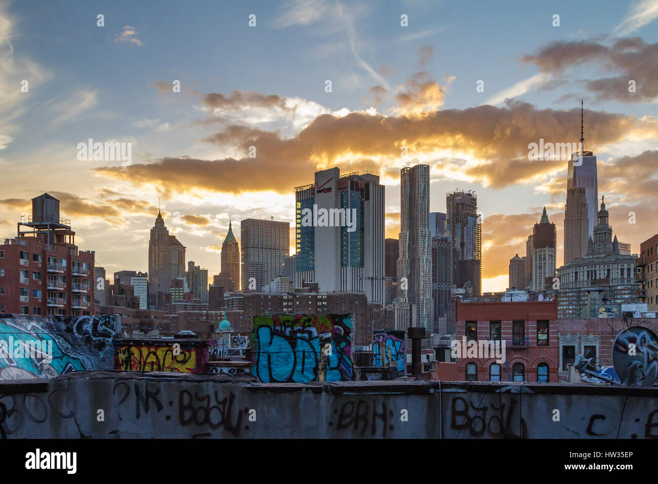 NEW YORK CITY - 24 février : Le soleil se couche derrière les gratte-ciel de Manhattan et les toits couverts de graffitis de Chinatown dans N Banque D'Images