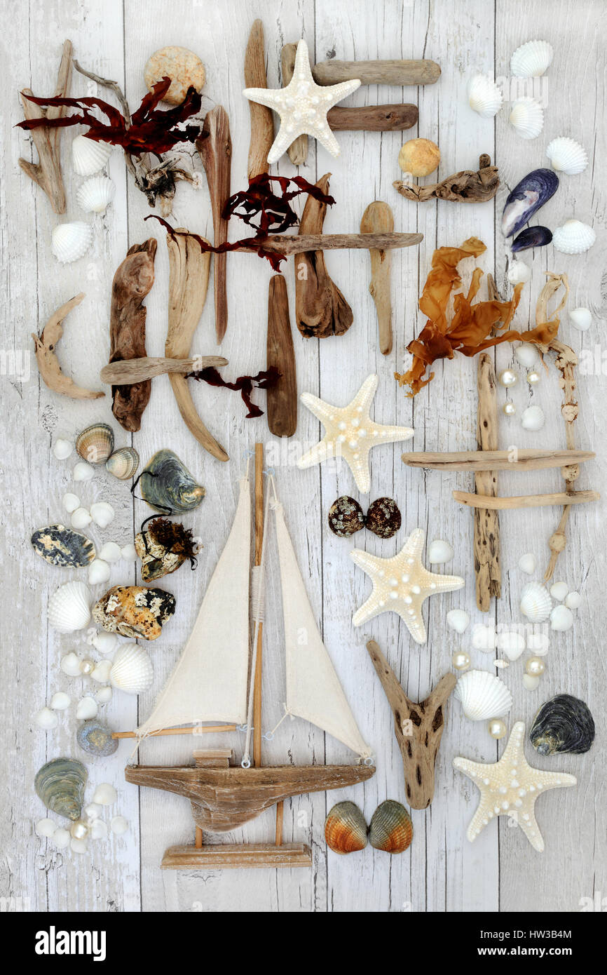 Résumé station collage décoratif avec bateau à voile, bois flotté, coquillages, pierres, perles et des algues sur le fond en bois blanc en détresse. Banque D'Images