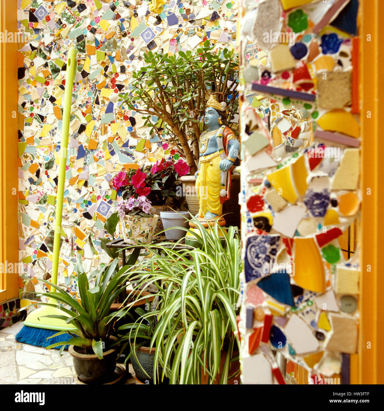 Des murs en mosaïque et des plantes en pot. Banque D'Images
