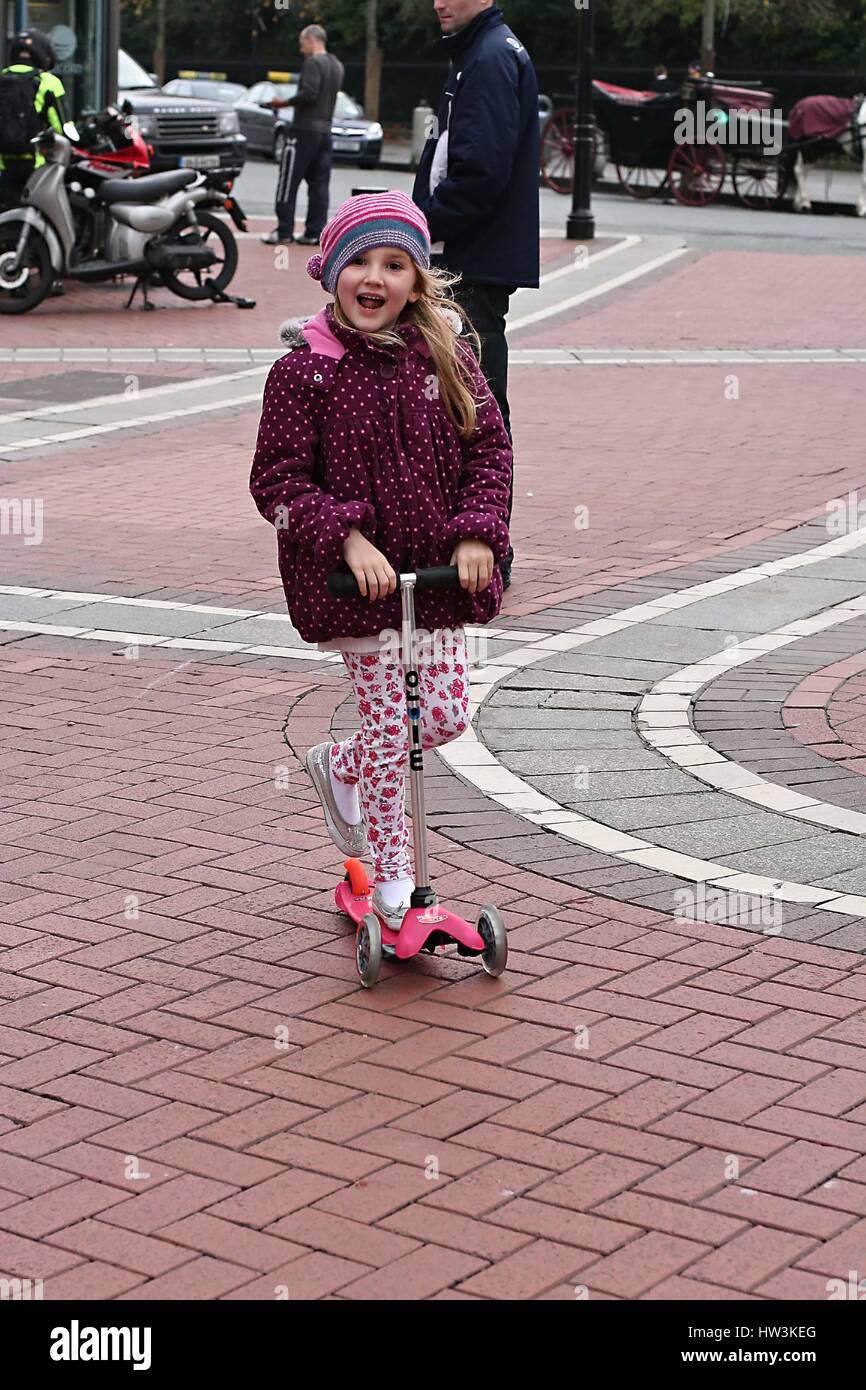 Petite fille jouant sur son scooter dans la ville, la liberté scooting concept, me demande la petite enfance insouciante liberté temps heureux joie douce enfant blonde concept Banque D'Images