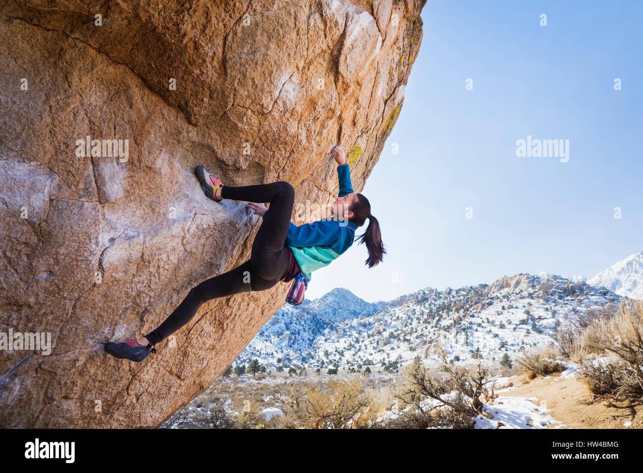 Mixed Race girl climbing rock Banque D'Images