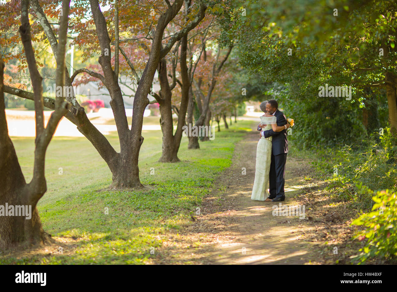 Black couple hugging on path in park Banque D'Images
