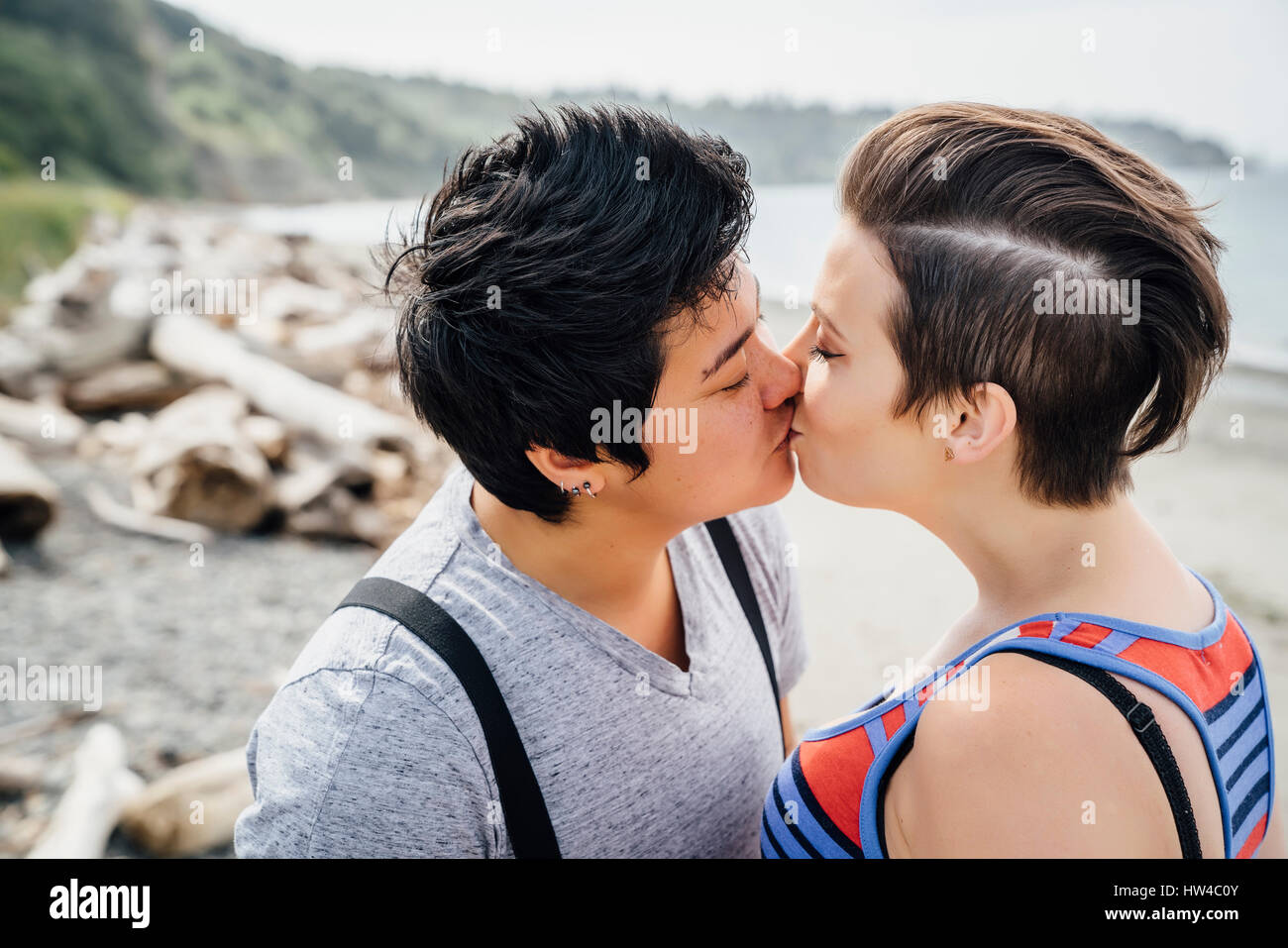 Lesbiennes enceintes couple kissing on beach Banque D'Images