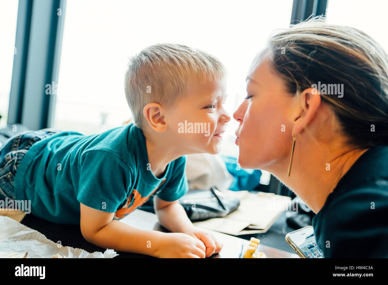 Mère embrassant fils portant sur la table Banque D'Images
