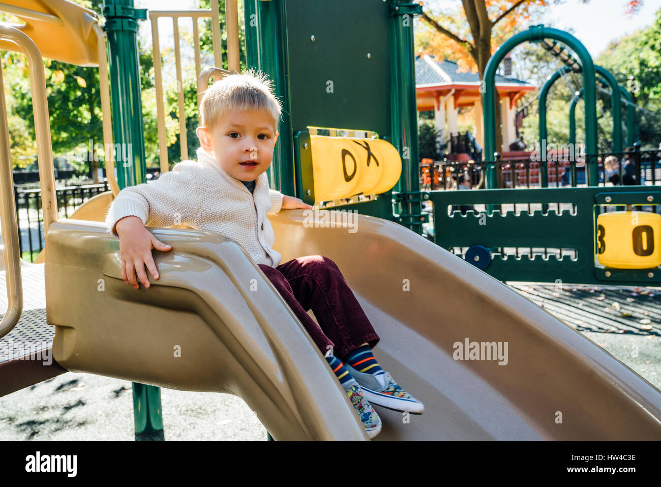Portrait of young woman sitting on playground slide Banque D'Images