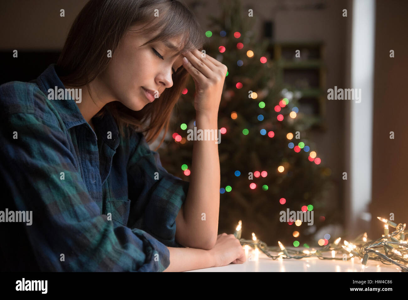 Mixed Race woman avec maux near Christmas Tree Banque D'Images