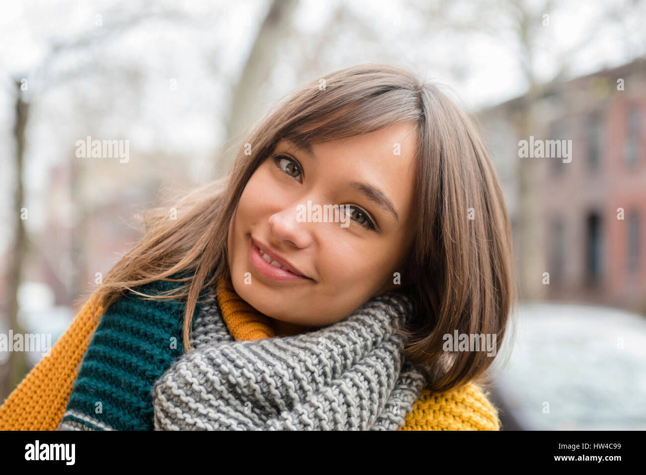 Portrait of smiling woman wearing scarf in city Banque D'Images