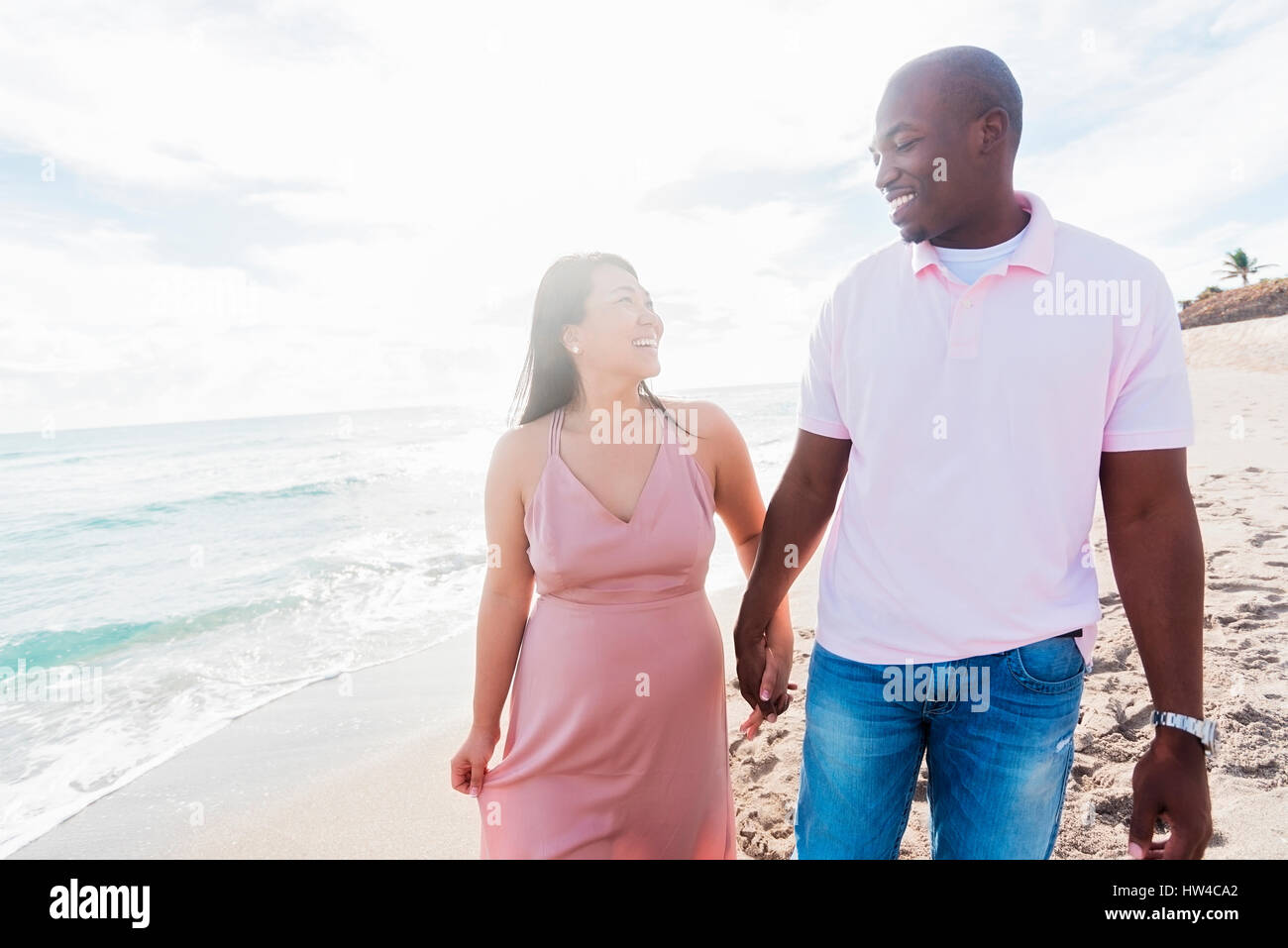 Couple holding hands walking on beach Banque D'Images