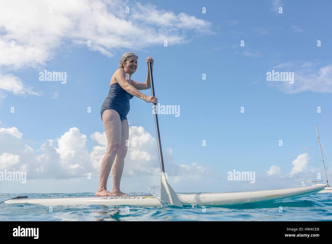 Caucasian woman standing on paddle board on ocean Banque D'Images