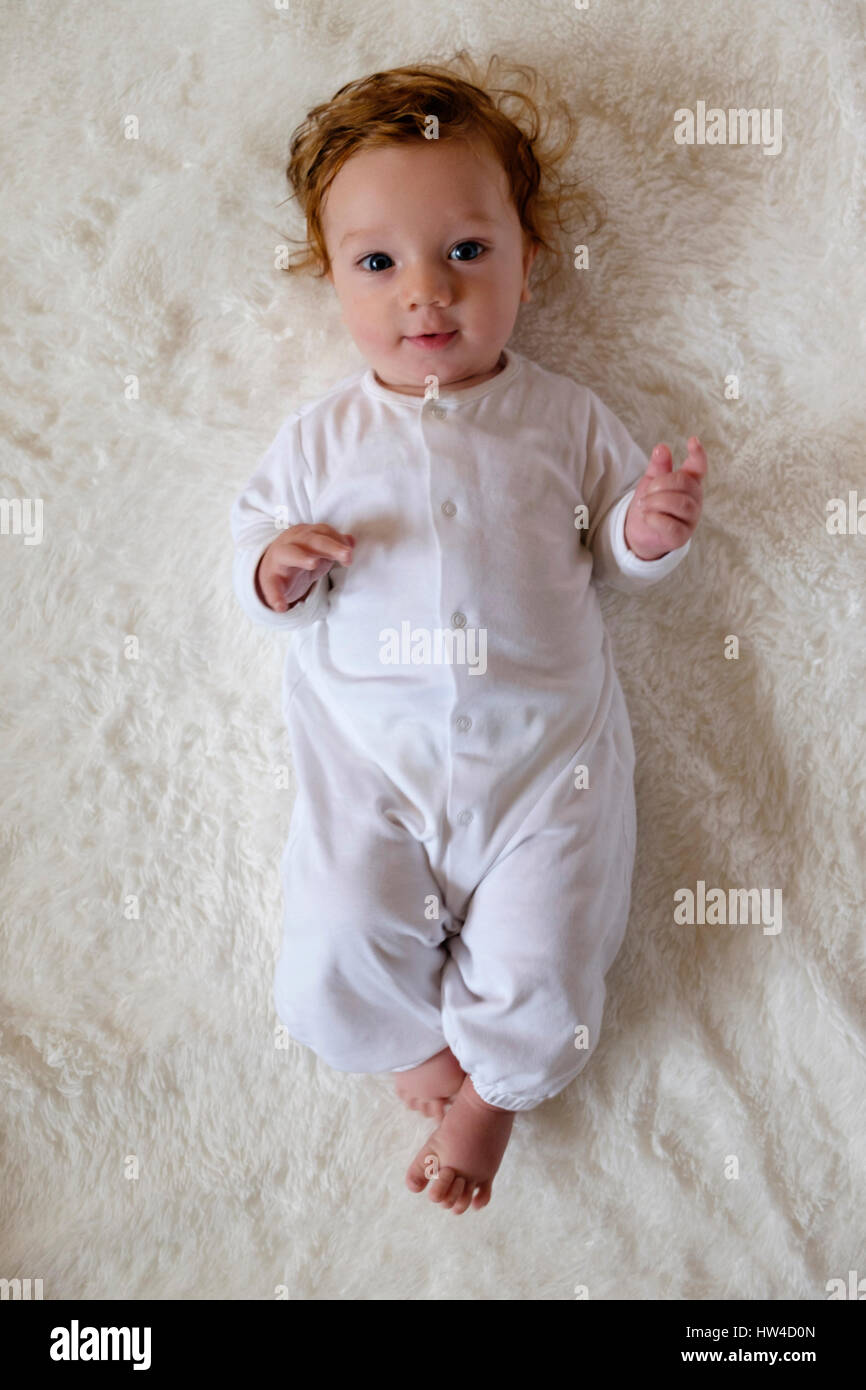 Portrait of Caucasian baby boy portant sur la couverture de fourrure blanche Banque D'Images