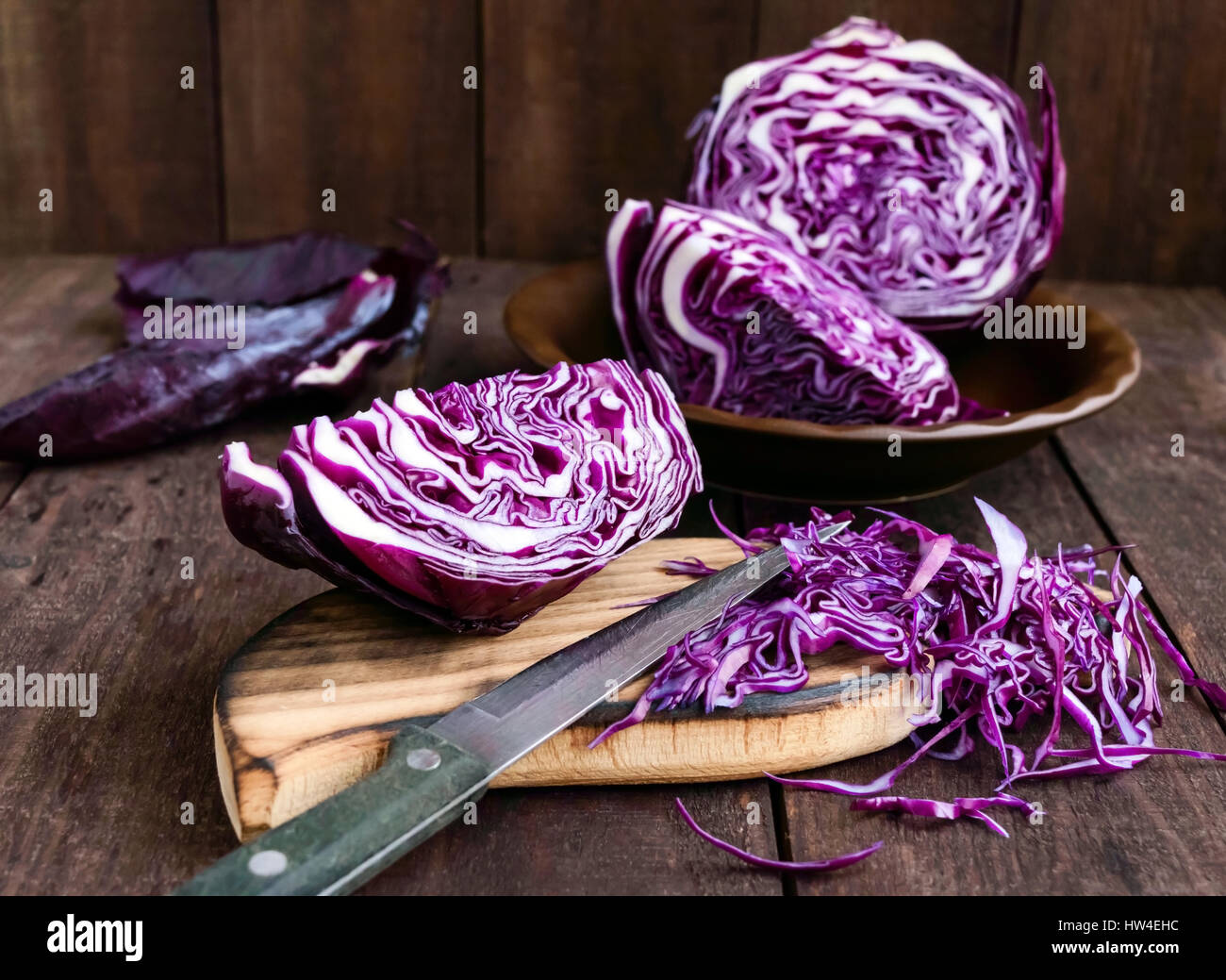 Chou rouge couper en morceaux avec un couteau sur un fond de bois sombre.  Ingrédient pour la cuisson des plats de légumes Photo Stock - Alamy
