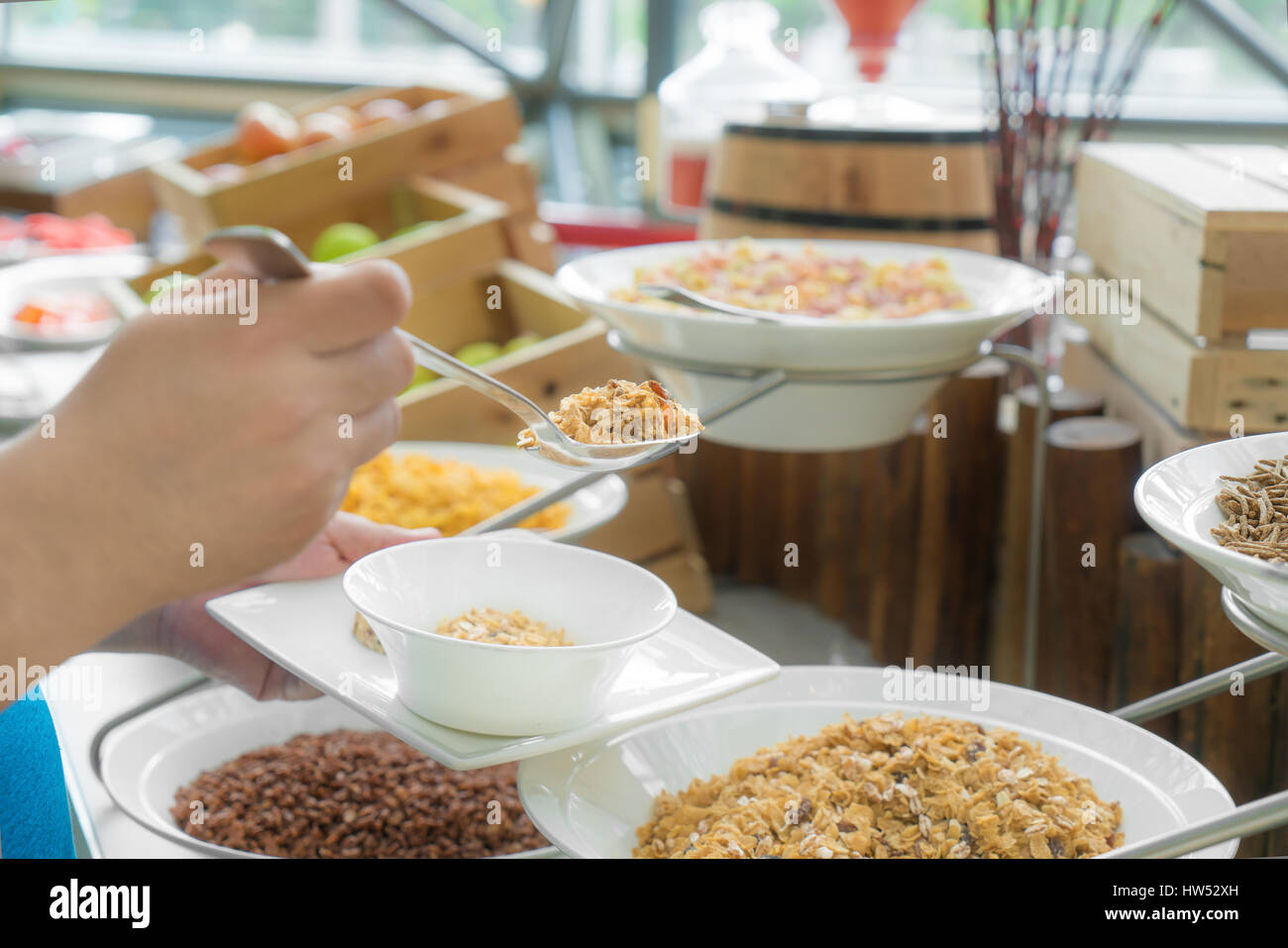 Cuillère à la main une sorte de céréales sur un self service petit-déjeuner dans un hôtel restaurant. Banque D'Images