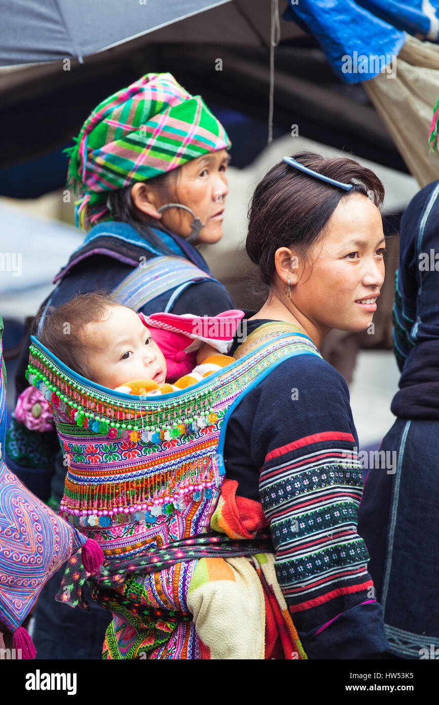 Sapa, SAPA, Vietnam - 6 mai 2014 : Portrait de femme Hmong tribal avec bébé dans les vêtements nationaux sur le marché local, SAPA, Vietnam du Nord. Banque D'Images