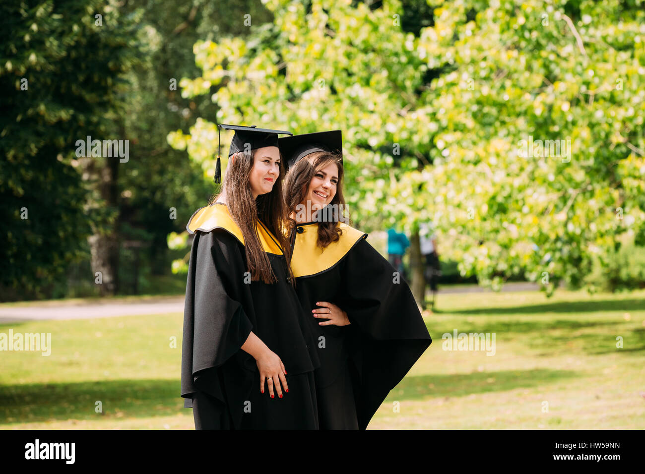 Riga, Lettonie - 1 juillet 2016 : Deux jeunes femmes diplômées de l'Université de Lettonie habillé en robe de chambre et les diplômés universitaires Square caps qui pose pour la photo Banque D'Images