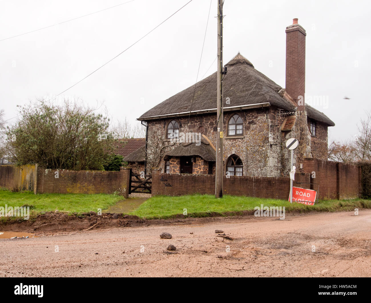 Villa en pierre. Près de Exeter, Devon. Cottage, anciennement un péage. c1800. Grès rouge et piège décombres avec chaînages piège pyramidal et toit de chaume . Banque D'Images