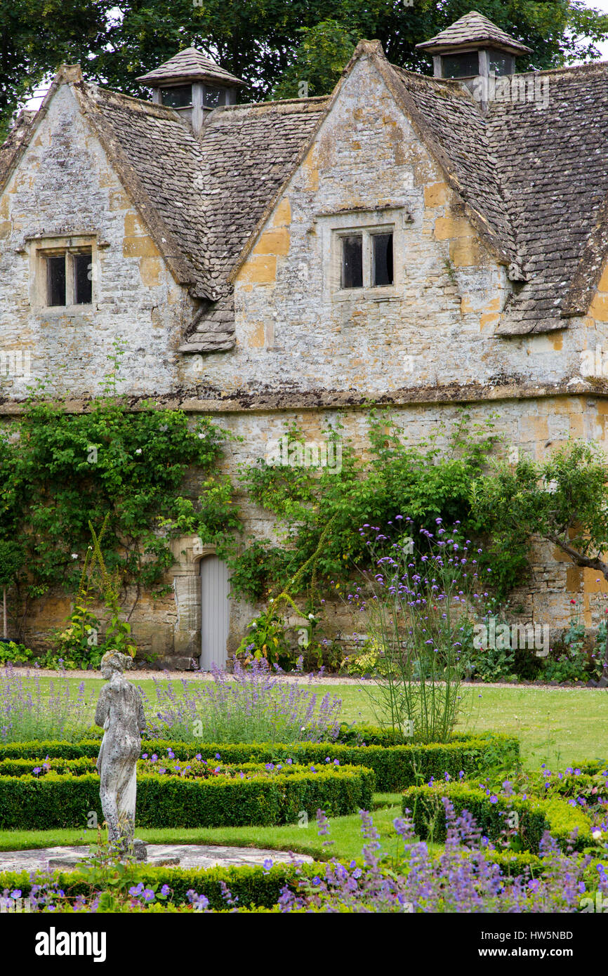 Statue de jardin et de fleurs à Lower Slaughter Manor House, Lower Slaughter, les Cotswolds, Gloucestershire, England, UK Banque D'Images