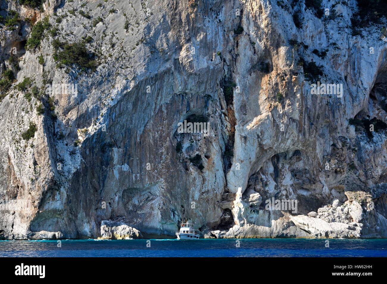 Italie, Sardaigne, Mer Tyrrhénienne, golfe d'Orosei, parc national du Gennargentu, la côte sauvage falaise, bateau voyageant le long des rochers Banque D'Images