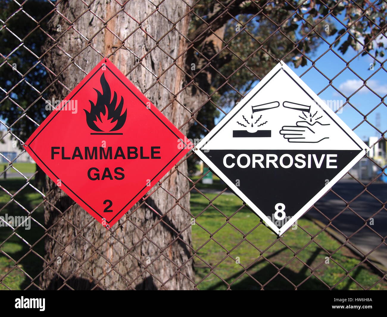 Les panneaux pour les liquides inflammables et substances corrosives à une clôture, Melbourne 2016 Banque D'Images