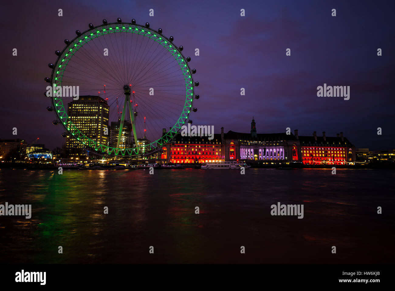 London Eye et County Hall la nuit. Pour marquer, Patrick's Day, les lumières du London Eye ont été allumées au vert Banque D'Images