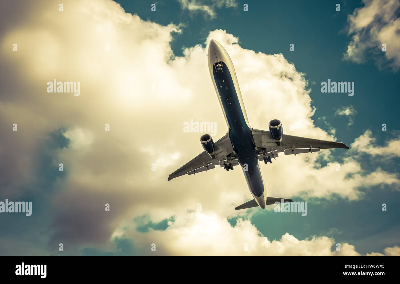 Tons rétro passenger jet à l'atterrissage approche à travers un ciel nuageux Banque D'Images