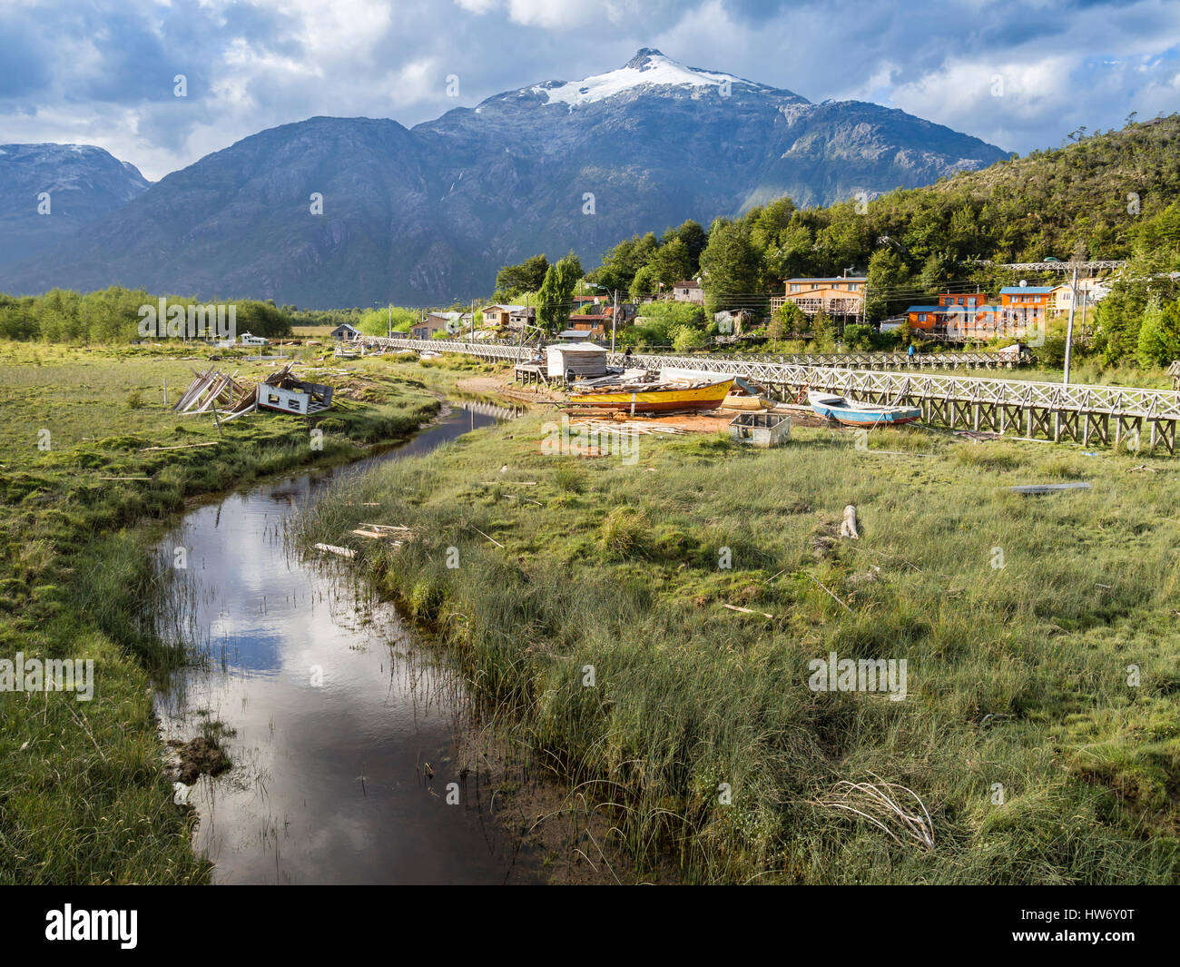 Vue sur les prés marécageux, maisons et promenade en bois de Caleta Tortel, montagnes à l'arrière, la région d'Aysen, en Patagonie, au Chili Banque D'Images