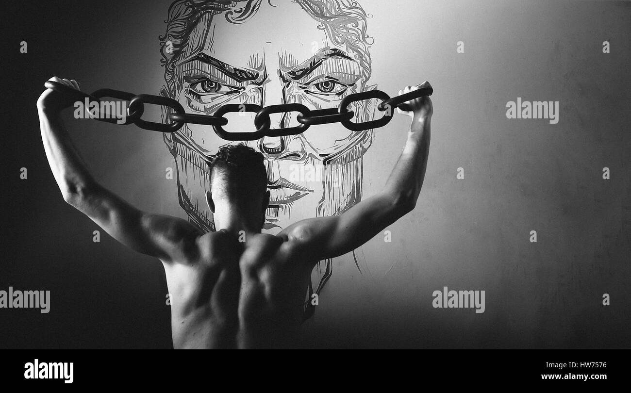 Un jeune homme dans une chaîne noire soulève au-dessus de sa tête. Le concept de liberté, ou des sports. le noir et blanc stylisé Banque D'Images