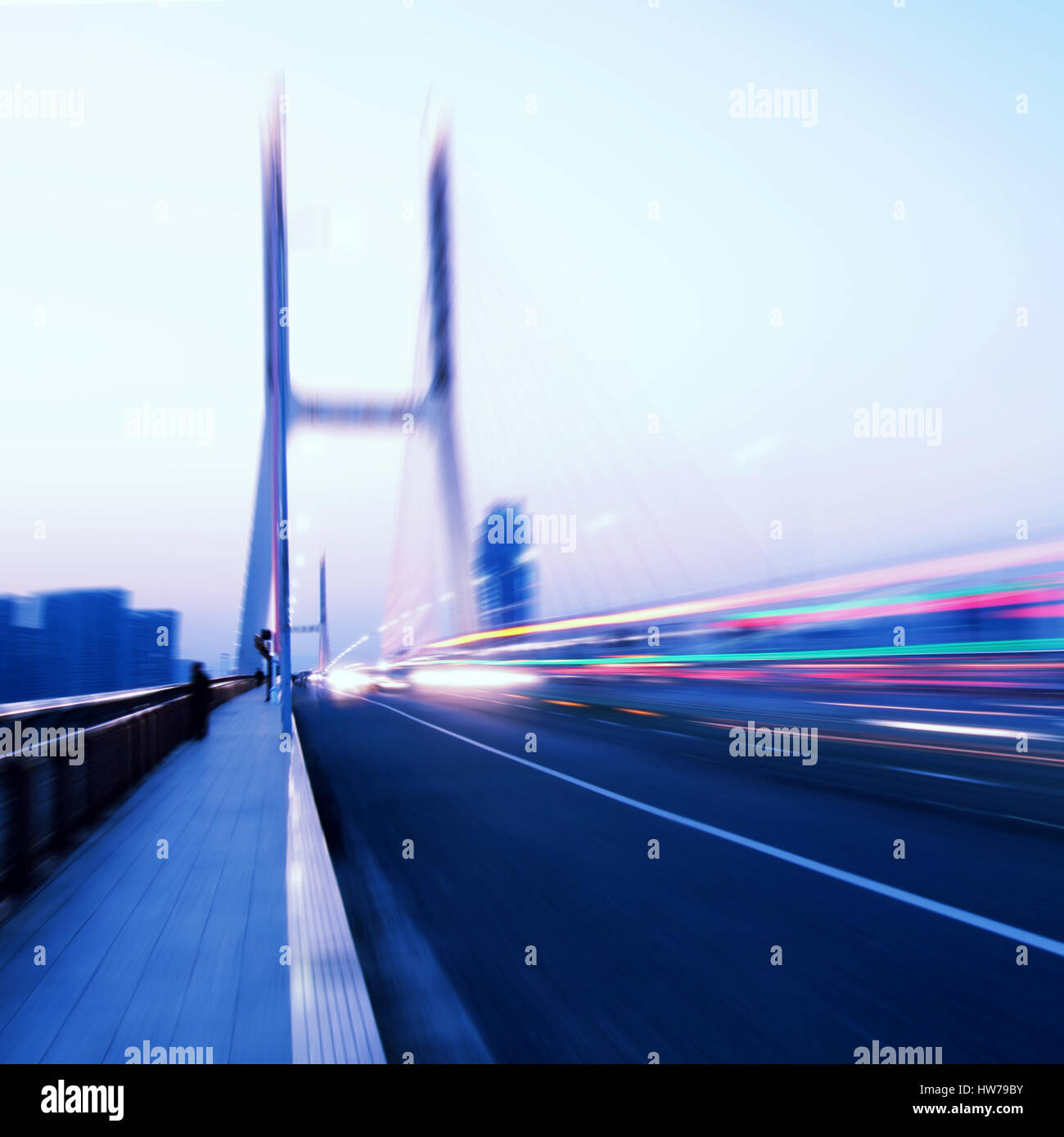 La lumière des voitures traine sur le pont moderne au crépuscule Banque D'Images