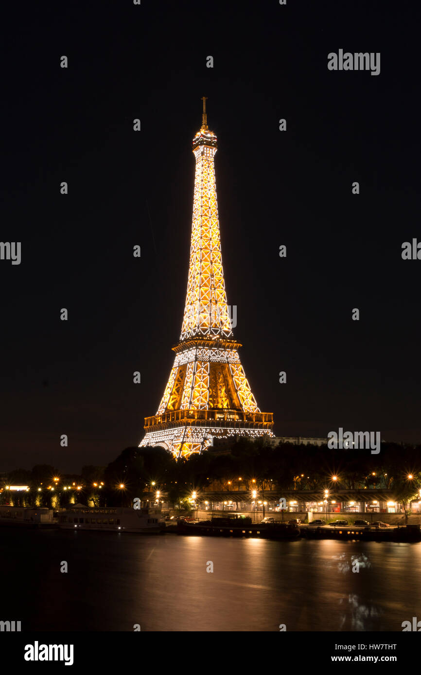 PARIS, FRANCE- 6 octobre 2016 : Tour Eiffel depuis les quais de Seine la nuit car il s'allume sur l'heure. Banque D'Images