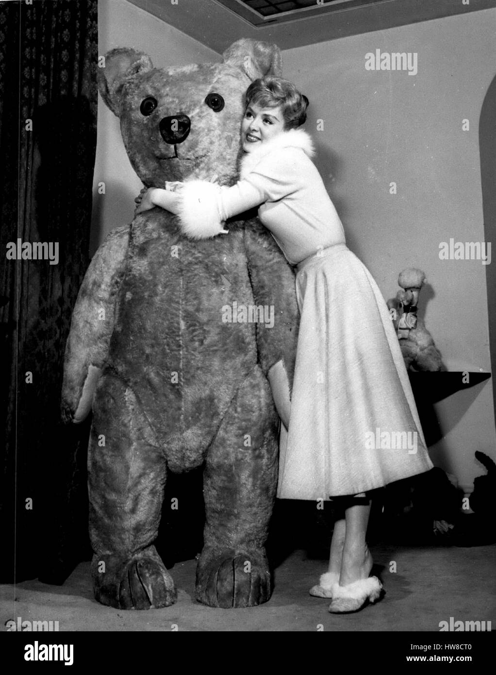 1957 - ''Yana'' - introduit ''Entente Cordiale''. Star de la chanson et ses énormes nounours. la télévision populaire chanteur Yana est un passionné des mascottes - dont elle a une grande collection d'ours - pour la plupart - les chiens bourrés etc. sa préférée est un énorme ours en peluche qui mesure 6ft. 4po. de hauteur - et qu'elle a ''mnamed Entante Cordiale'' - parce qu'elle dit qu'il est si gentil avec tout le monde. Yana est maintenant au haut de gamme de loi au prix de Wales Theatre. La photo montre la Yana fait un fuds de ''entente cordiale'' - à Londres son oime. (Crédit Image : © Keystone Photos USA/ZUMAPRESS Banque D'Images