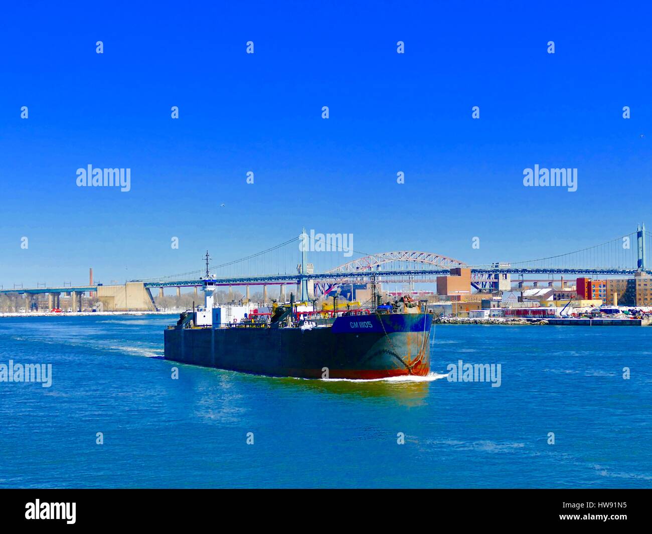 Bateau/barge vagues sur l'East River sur la pureté de l'hiver journée avec pont RFK en arrière-plan. Les bâtiments de la rive. New York, NY, USA Banque D'Images