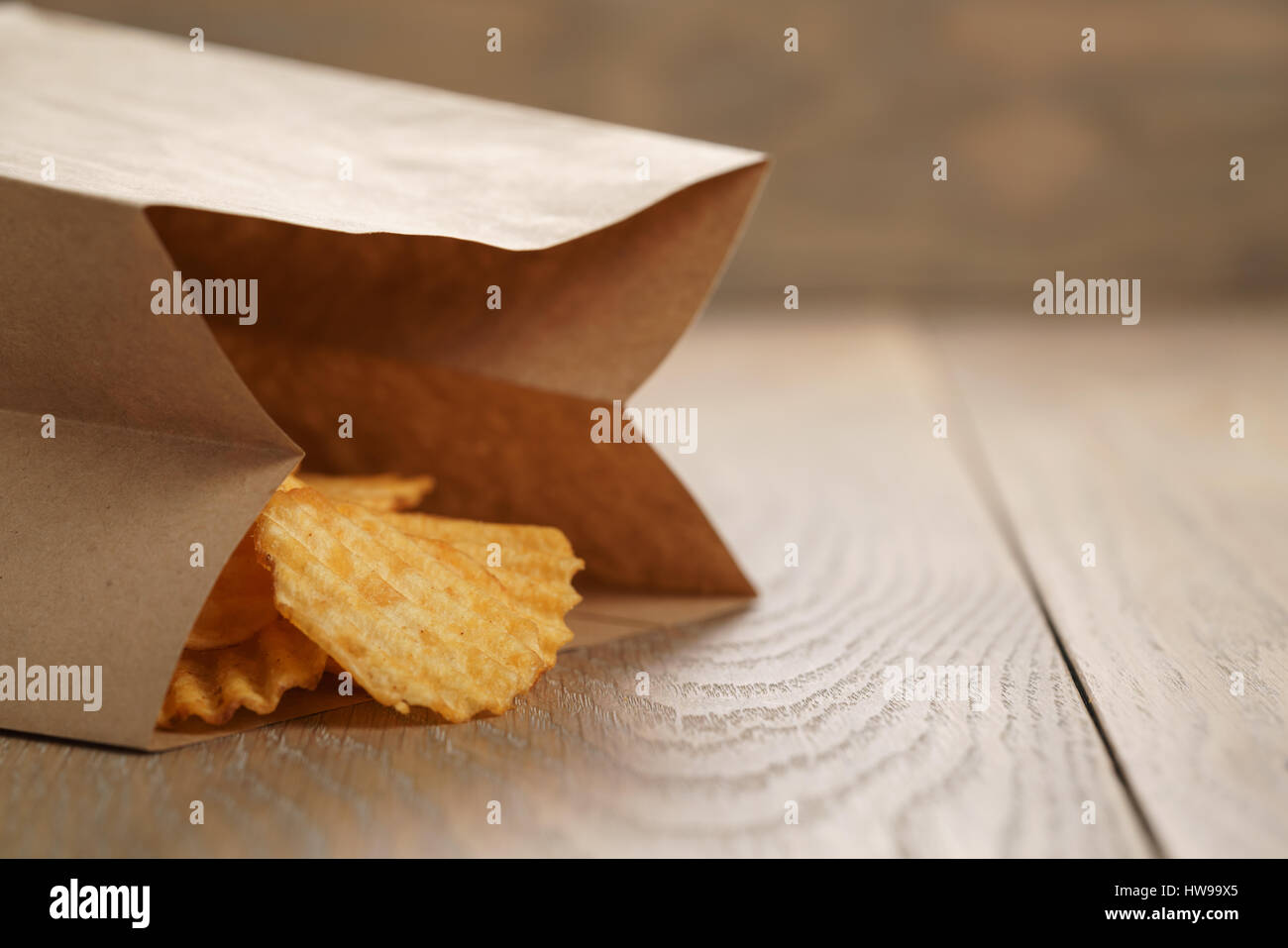 Chips de pomme de terre ridée de paprika en sac de papier Banque D'Images