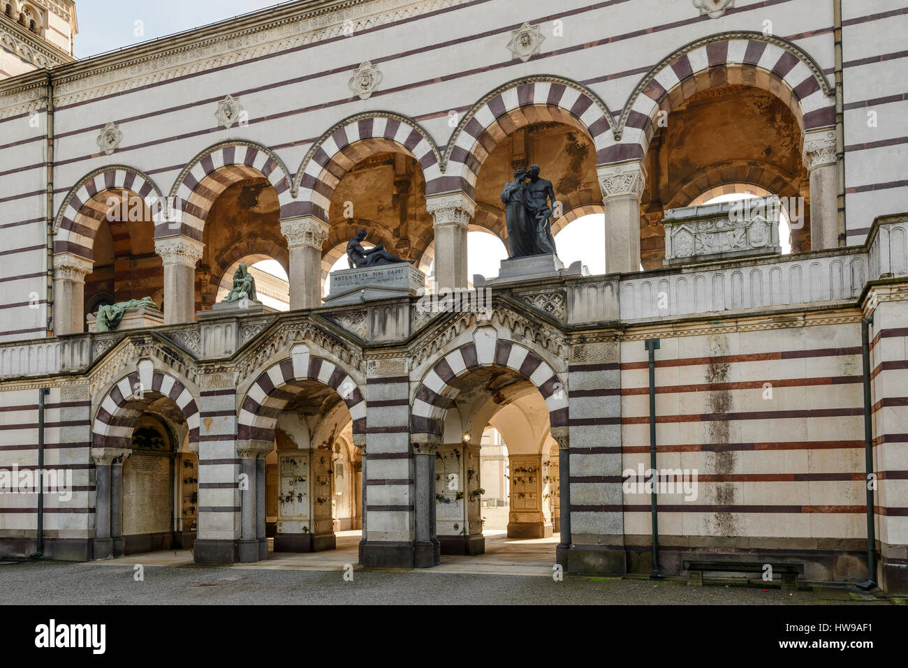 Une vue de l'arches multiples de passage d'entrée au grand cimetière monumental de la ville, tourné à la fin de l'hiver lumineux lumière à Milan, Lombardie, Italie Banque D'Images
