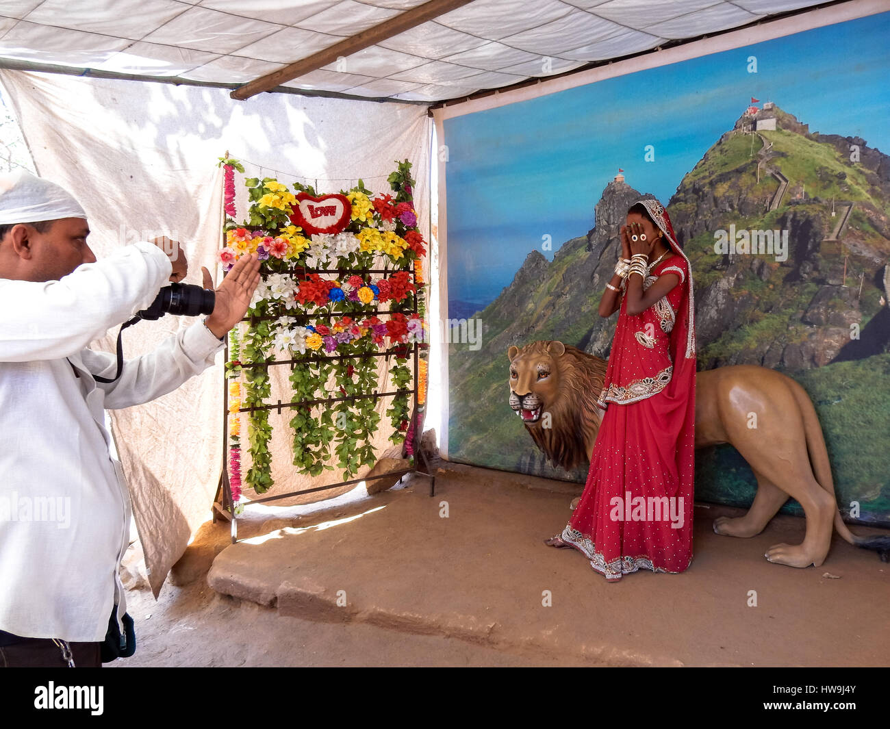 L'homme prend phote de femme avec de faux lion à studio à junagadh, Inde Banque D'Images